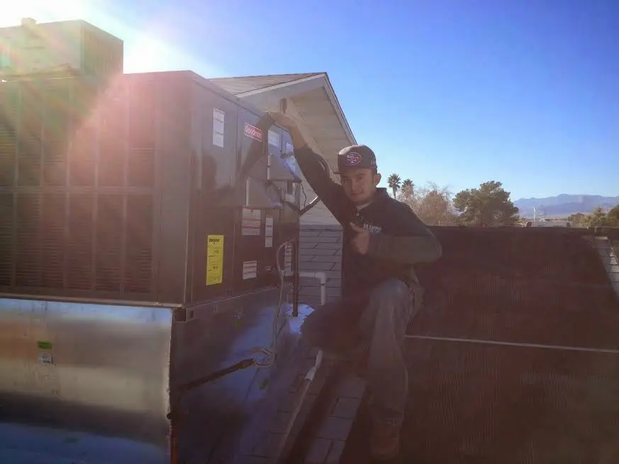 HVAC technician performing AC Tune-Up on a rooftop unit in West York