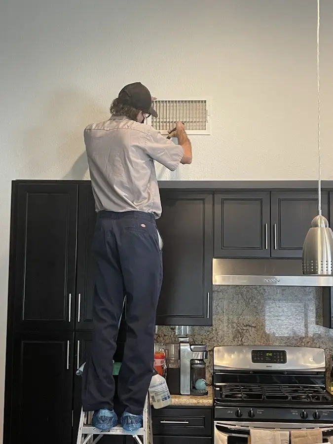 Technician inspecting an air vent during HVAC service in West York